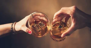 Close-up of friends toasting with whisky during a tasting of Indian, Scotch, and Bourbon whiskies